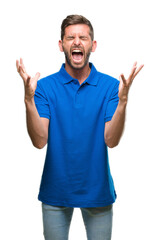 Young handsome man over isolated background celebrating mad and crazy for success with arms raised...