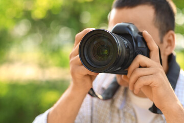 Male photographer with modern camera outdoors