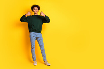Naklejka premium Full size photo of nice young man thumb up empty space wear pullover isolated on yellow color background