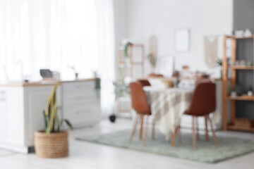 Blurred view of light dining room with table and counters near window