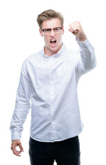 Naklejka premium Young handsome blond man angry and mad raising fist frustrated and furious while shouting with anger. Rage and aggressive concept.