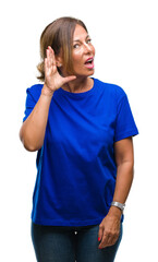 Middle age senior hispanic woman over isolated background smiling with hand over ear listening an hearing to rumor or gossip. Deafness concept.