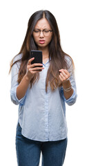 Fototapeta premium Young asian woman texting using smartphone over isolated background annoyed and frustrated shouting with anger, crazy and yelling with raised hand, anger concept