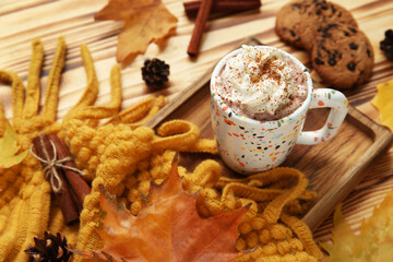 Autumn composition with cup of cocoa, scarf and cookies on wooden background, closeup