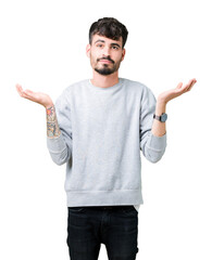 Young handsome man wearing sweatshirt over isolated background clueless and confused expression...