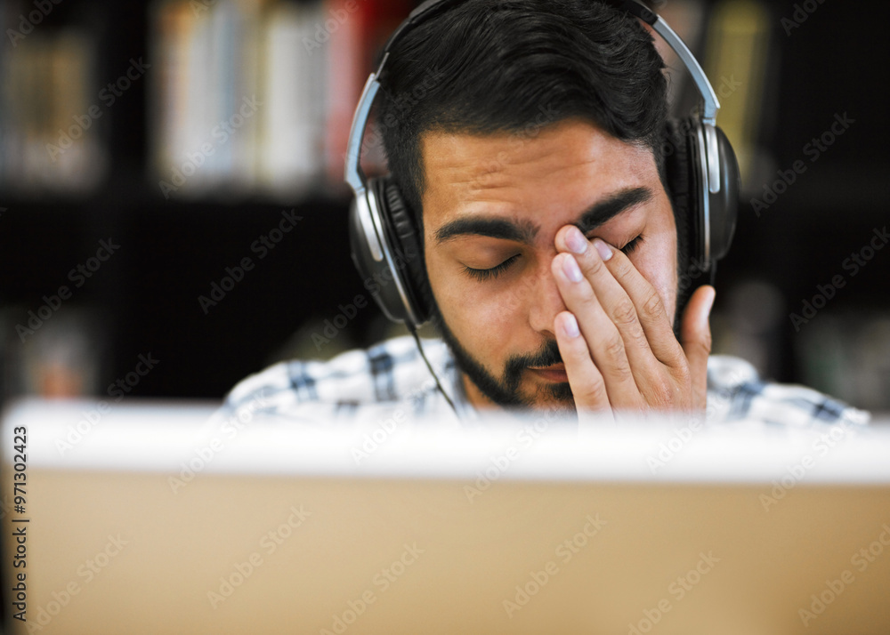 Poster Man, university student and tired on computer with headphones in library for internet, online error and research. Male person, exhausted and burnout or headache with assignment deadline and study