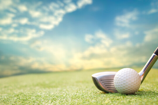 A golf ball and club are set against a beautiful sky, symbolizing sport and leisure on the green fields of a golf course.