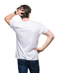 Young handsome man wearing casual white t-shirt over isolated background Backwards thinking about doubt with hand on head