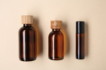 Essential oils in bottles on beige background, flat lay