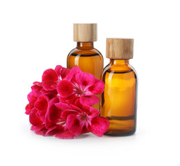 Geranium essential oil in bottles and beautiful flowers isolated on white