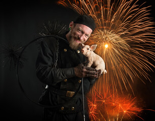 Schornsteinfeger in Arbeitskleidung begr&uuml;&szlig;t das Neue Jahr mit Feuerwerk.