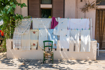 Τraditional weavers and clothes outside a house in the village of Anogeia in Rethimno, Crete, Greece