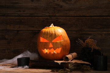 Halloween pumpkin and witch's attributes on wooden background