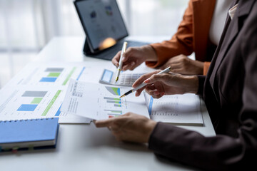 Business team analyzing financial charts and graphs on desk