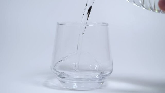 Pour Water Into Empty Glass Isolated On White Background
