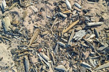 A pile of wood and debris on the beach. The image has a mood of sadness and destruction