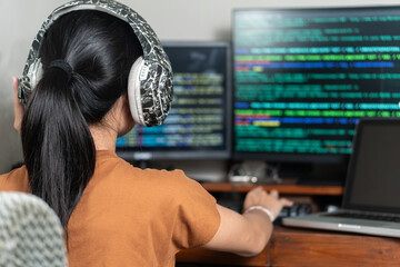 Focused Programmer with Headphones in Tech Workspace