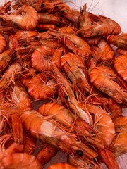 Vibrant whiteleg shrimp basking in a sea of orange, freshly harvested in coastal waters during a sunny morning