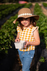 A young girl wearing a yellow and white checkered shirt