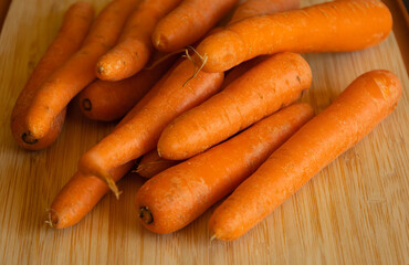 Bunch of Fresh Organic Carrots on a Wooden Chopping Board Close-Up