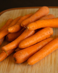 Bunch of Fresh Organic Carrots on a Wooden Chopping Board Close-Up
