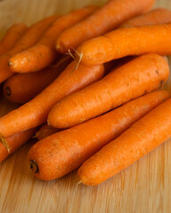 Bunch of Fresh Organic Carrots on a Wooden Chopping Board Close-Up