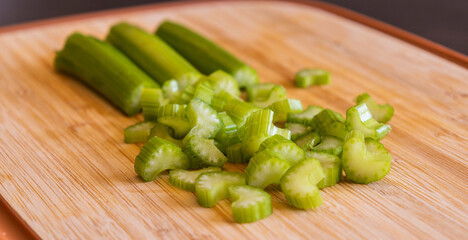 Fresh Organic Chopped Celery Sticks on a Wooden Chopping Board Close-Up