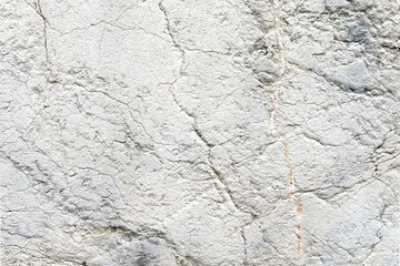 Distressed aged gray stone wall with cracks and scratches of abstract surface