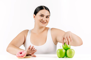 Young, full-figured woman faced with the choice between healthy food and unhealthy options. Perfect...