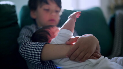 Young boy cradling newborn sibling with gentle sunlight, showcasing the nurturing bond and serene atmosphere in a cozy family home