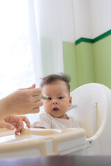 The baby is lazy to eat on the high chair