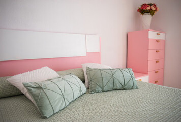 Pretty boho styled bedroom with fresh cut flowers and pink sheepskin