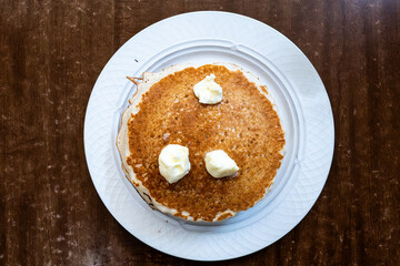 A stack of American pancakes with butter.
