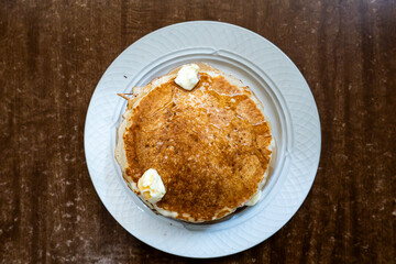 A stack of American pancakes with butter.