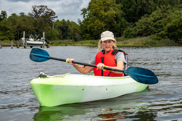 Broiomes Island, Maryland USA A woman kayaks in the Patuxent River in the summer.