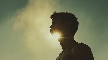 Facing my Faith. Silhouette of a young man against sunbeams in the sky.