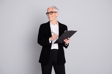 Photo of lovely gorgeous successful senior lady wear black trendy suit look empty space isolated on grey color background