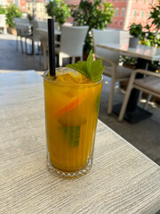 Lemonade with orange, ice and mint on the cafe table. Close-up. Warsaw. Poland.