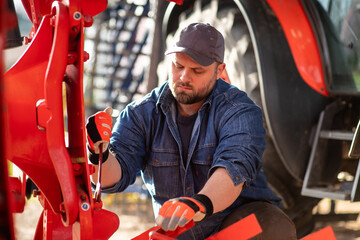 The farmer repairs agricultural machines