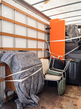 The inside of a removal van, showing fabric blankets , furniture and sofa. Concept for moving home, furniture protection, storage, packing and transportation. Copy space.
