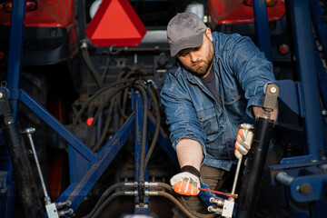 The farmer repairs agricultural machines