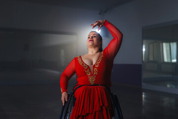 Woman with a disability, a para dancer practicing choreography at the dance studio, making wheelchair spin and elegant arm moves.