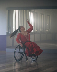 Beautiful dance in a wheelchair of a woman with disability at a dancing studio. Para dance sport. © 24K-Production