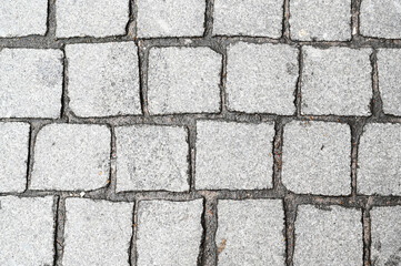 Granite stone block paving background. Paving work on a sidewalk, yard, home. Paving stone floor laying brick by landscape gardener.