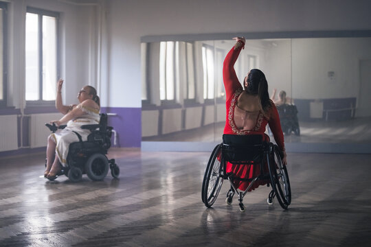 Para dance sport, two determined women with disability enjoy practicing elegant and stylish movements on wheelchair.