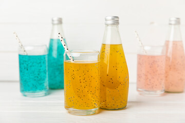 Diet detox cocktail with basil and chia seeds in a glass jar and a glass on a textured background....