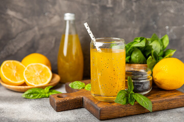 Diet detox cocktail with basil and chia seeds in a glass jar and a glass on a textured background....
