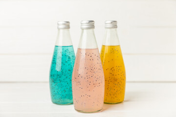 Diet detox cocktail with basil and chia seeds in a glass jar and a glass on a textured background....