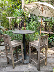 Obraz premium Old wooden table and chair with the white umbrella.