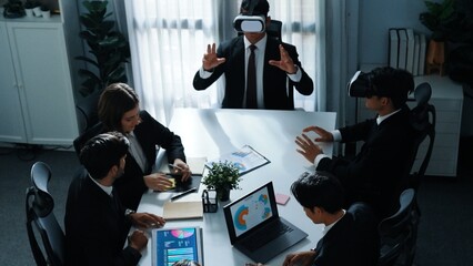 Top view of manager working on laptop and sending data analysis to business people by using VR glass headset while diverse team planning marketing strategy and looking at financial graph. Directorate.